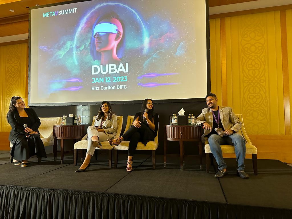 Afzal seated on a panel discussion stage